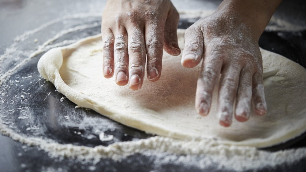 Pizza Dough Being Stretched